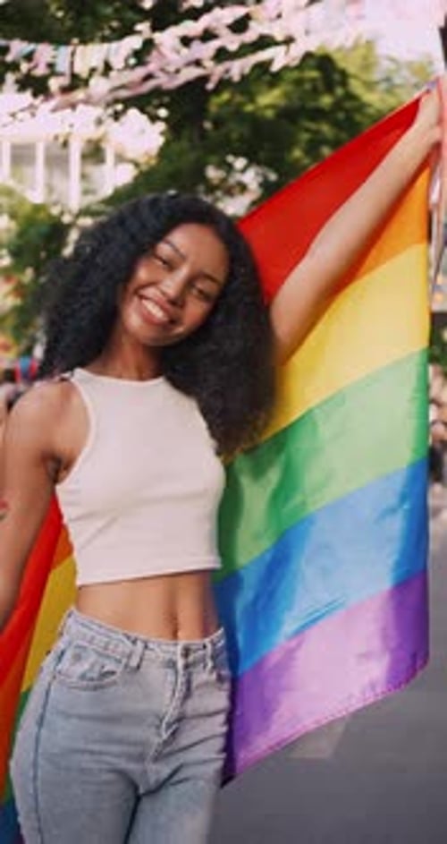 Vertical clip. A young black woman shows off her homosexual identity in a pride parade.
