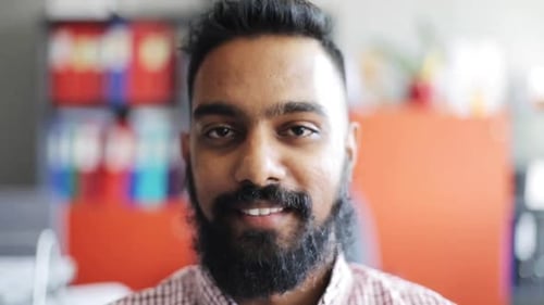 Happy indian businessman smiling joyfully in office slow motion