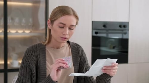 Woman Reads Medication Instructions in Kitchen
