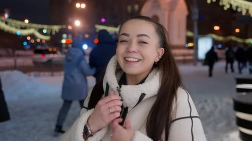 Euphoric Woman in Cream Jacket Amidst City Nightlife