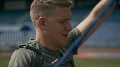 Man Exercising with Resistance Band at Stadium