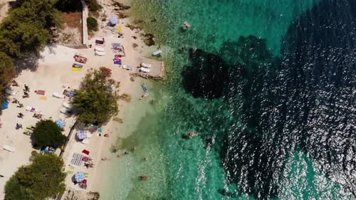 Aerial top view of sand and rock beach with crystal clear water in Croatia Adriatic