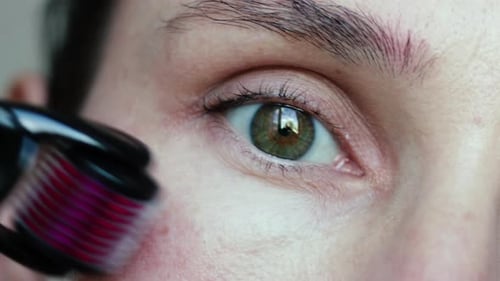 woman eye close up remove pluck eyebrows hair or massaging under with derma roller