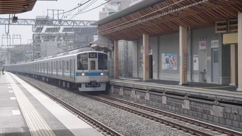Japanischer Zug kommt während der Pandemie in Tokio, Japan, am leeren Bahnsteig des Bahnhofs an. - breit,