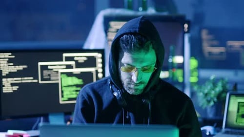 A Cybersecurity Expert is Diligently Working Late at Night in a Dimly Lit Office Space