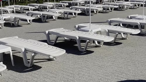 Empty Poolside Sun Loungers in a Resort on a Bright Sunny Day
