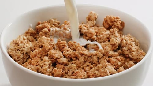 Milk Pouring Into Bowl of Cereal Pieces