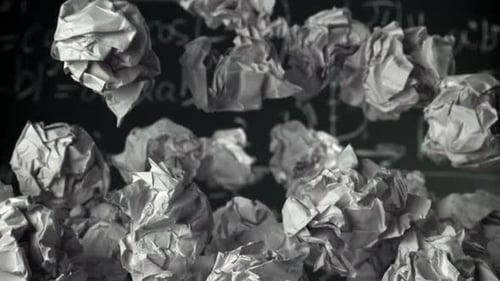 Crumpled Paper Rises and Falls Against the Background of the Blackboard Filmed on a Highspeed Camera