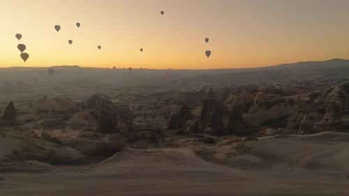 Drone view of hundreds of colorful hot air balloons soaring at sunrise in Cappadocia