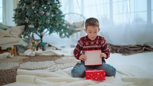 Boy Opening Christmas Gift in a Cozy Home