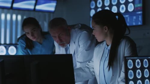 Diverse Team of Medical Scientists Solve Problems and Point at Computer Screens Showing CT, MRI Sca