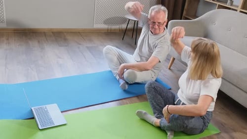 Couple Exercising Together at Home on Yoga Mats