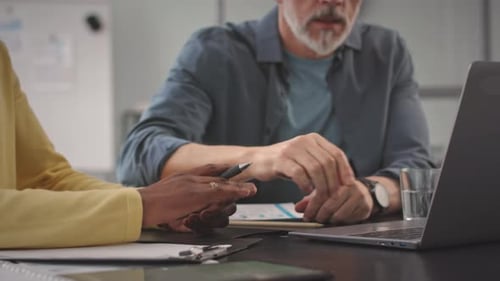 Two Adults Working Together on a Laptop in Office