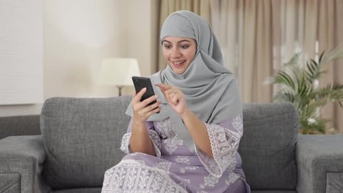 Woman using smartphone in her living room
