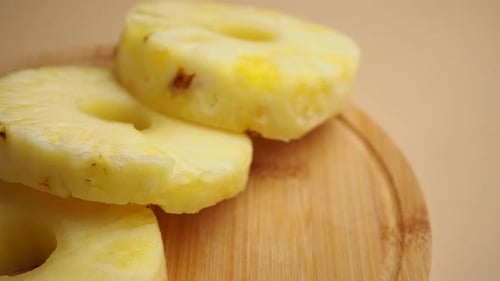 Close Up of Pineapple Slices on Wooden Plate