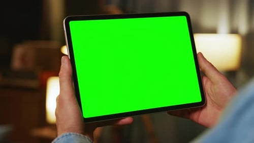 Hands Man Holding Tapping on Tablet Computer with Horizontal Green Screen Mock Up In the Evening