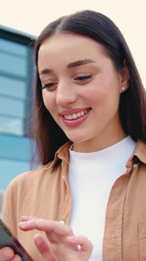 Side View of Close Up Females Hands Using Smartphone Typing a Message or Dialing Number on the