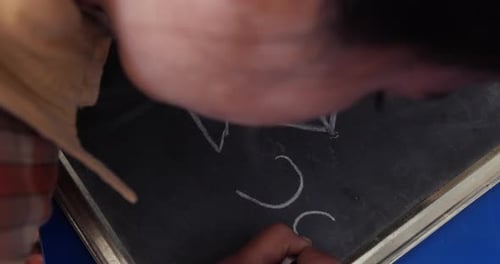 unidentified rural school student learning from chalkboard in the classroom of their school, scene i