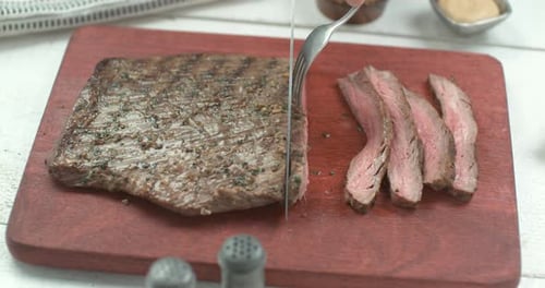 Delicious Medium-Rare Steak being Cut on Board