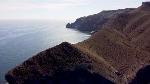 Seashore coastline drone aerial view of people at unspoiled beach in Almeria, Playa de los Muertos