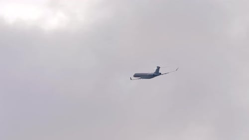 Airplane Flying High in the Cloudy Sky