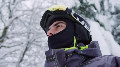 Person Putting on Ski Goggles in Snowy Setting