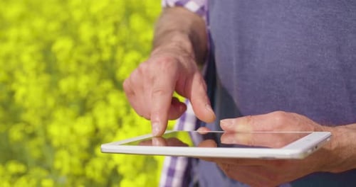 Mann tippt im Freien bei hellem Tageslicht auf Tablet