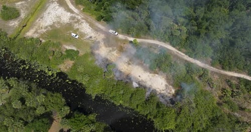 Wild Vegetation Fire Spreads Across Forested Landscape in Florida with Firefighters Working in Heavy