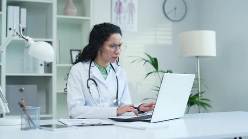Doctor Woman Working at Desk with Laptop
