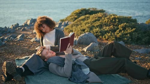 Libro de lectura Happy Sweethearts Ocean Seashore Cliff Date Hombre Acostado Mujer Rodillas