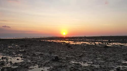Dramatisch Drohnenaufnahme der Küste bei Ebbe mit Spiegelung der Sonne auf der Insel Gili Trawangan, Bali,