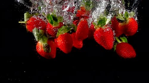 Super Slow Motion of Falling Strawberry Into Splashing Water