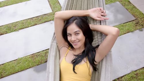 Woman Smiling and Relaxing in Hammock Outdoors