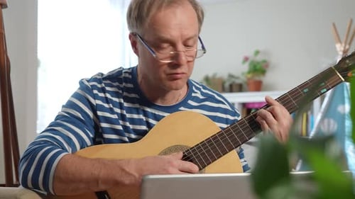 Un homme d'âge moyen jouant de la guitare acoustique