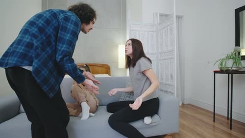 Parents Arguing as Daughter Watches on the Sofa