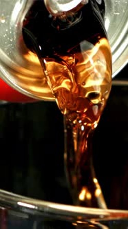 Cola is Poured From a Can Into a Glass