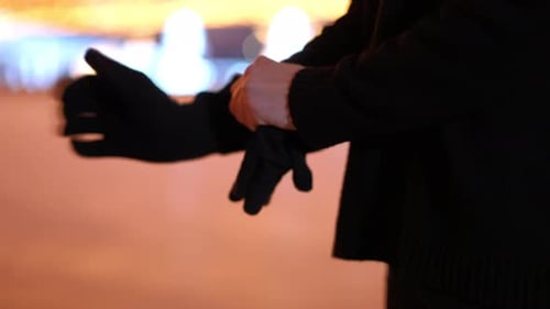 Closeup Side View Unrecognizable Woman Putting on Black Gloves Outdoors Young Caucasian Lady