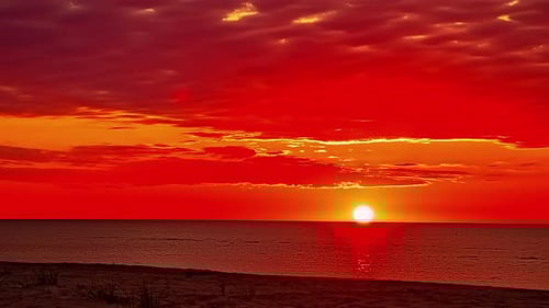 Beautiful colorful sunset at sea with dramatic clouds and sun shining