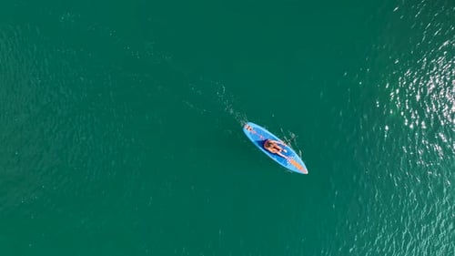 Aerial View Paddleboarding Adventure Through a Large Green Canyon in Nature