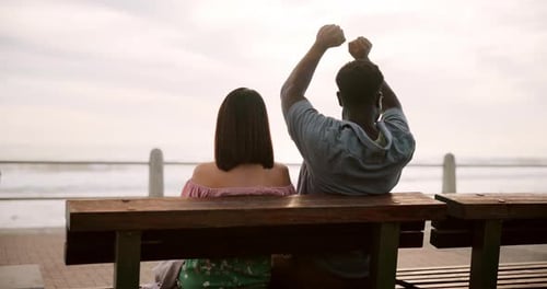 Romantic Couple Relaxing Together on Ocean Beachfront Bench