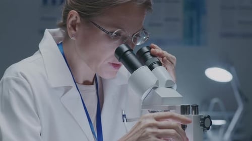 Female Lab Worker Using Microscope