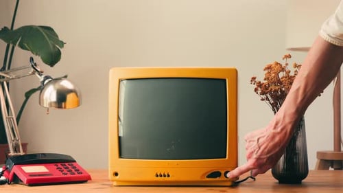 Hand Turns on Retro Television with Static Screen
