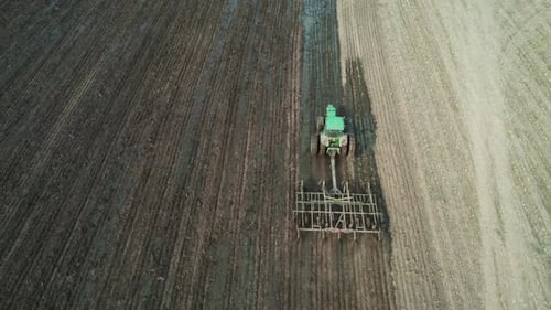 A tractor tills a Wisconsin farm field after a manure spreader has spread liquid manure on the farm