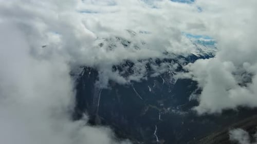 Aerial View of Snowcapped Mountains in Clouds