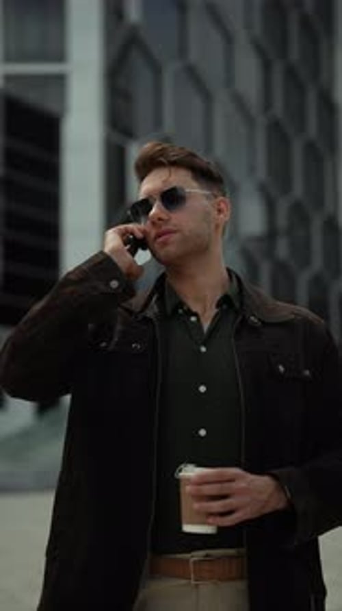 Young Man on Phone in City with Coffee