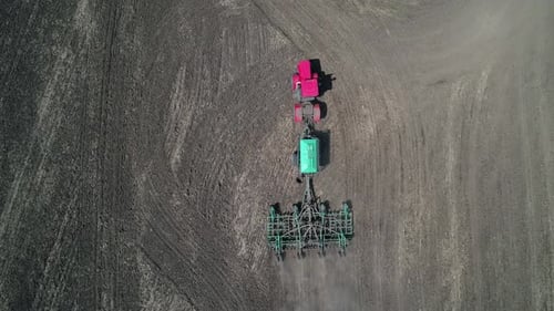 Aerial Top Down View of an Agricultural Tractor Performing Plowing Tillage for Sowing Crops A