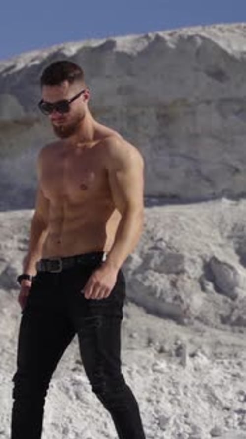 Shirtless Muscular Man Posing on White Rocks