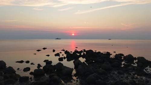 Drone Flying Over Calm Sea Waters Near a Yacht at Sunset