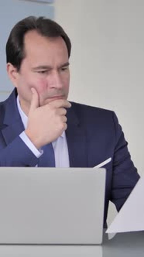 Businessman Reading Documents in Office, vertical video