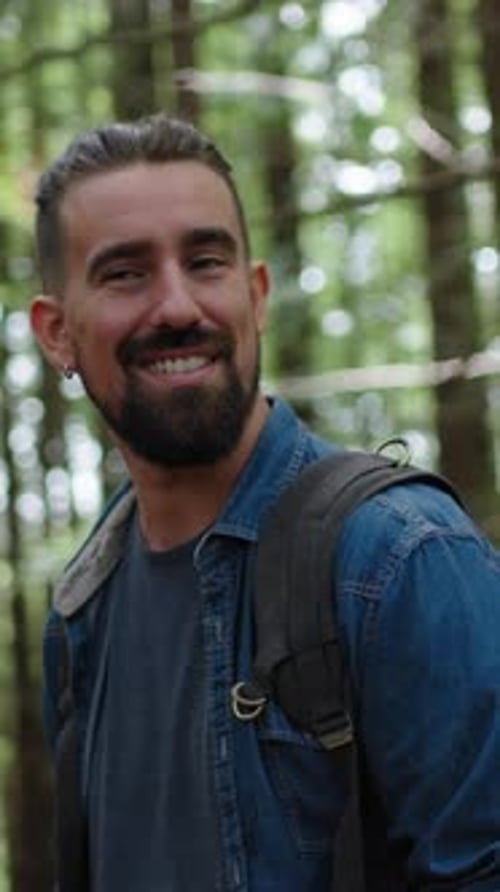 Glücklicher Mann steht im Wald und bewundert die Landschaft